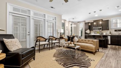 Contemporary open living room with a zebra-print rug and chic leather furniture at The Signature at Schilling Farms apartments in Collierville near Memphis.