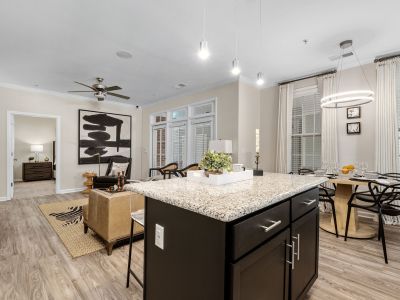 Open-concept floor plan looking from the kitchen island into the living and dining rooms at The Signature at Schilling Farms apartments in Collierville near Memphis.