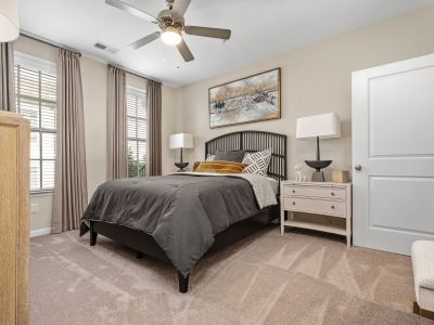 Staged bedroom with a dark metal slatted headboard, grey bedding, and neutral decor at The Signature at Schilling Farms apartments in Collierville near Memphis.