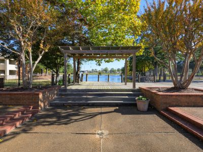 Wooden pergola over a waterfront viewing deck surrounded by autumn trees at Southcrest Lake Apartments in Southaven