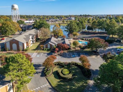 Aerial overview of the Southcrest Lake Apartments community grounds in Southaven, highlighting the residential buildings, outdoor pool, tennis courts, and central lake.