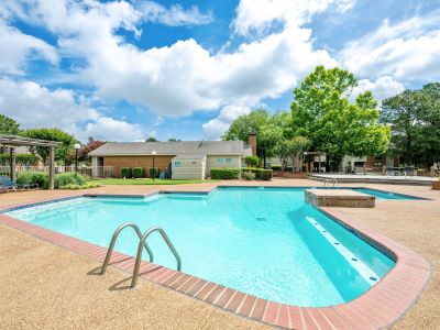 Sparkling outdoor swimming pool under a blue sky with a spacious sun deck and lounge seating at Southcrest Lake Apartments in Southaven