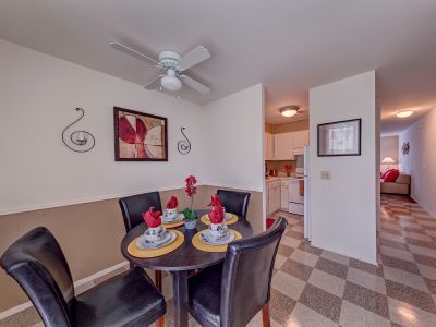 Cozy dining space featuring a round table, leather chairs, and a ceiling fan at Edison Park apartments in downtown Memphis.