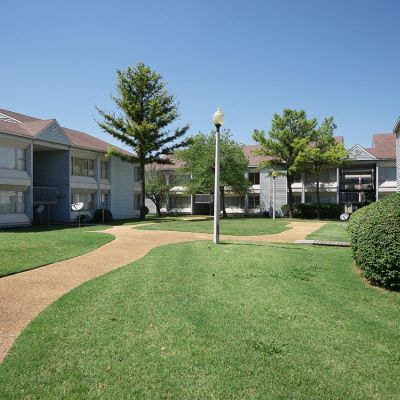 Paved courtyard walkway winding between residential buildings and green lawns at Edison Park apartments in downtown Memphis.
