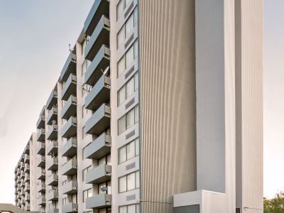 Angled view of the modern concrete and siding high-rise tower at Edison Park apartments in downtown Memphis.