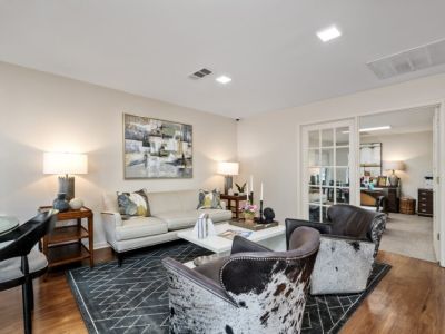 Clubhouse resident lounge showcasing contemporary armchairs, a neutral sofa, and decorative wall art at The Ellington at Kirby apartments in Memphis.