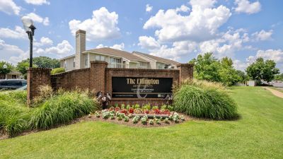 Angled exterior view of the brick property monument entrance sign for The Ellington Apartments in Memphis, bordered by a manicured lawn