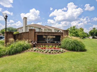 Angled exterior view of the brick property monument entrance sign for The Ellington Apartments in Memphis, bordered by a manicured lawn