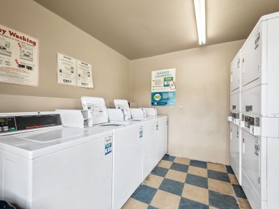 On-site laundry facility equipped with rows of commercial washing machines and stacked dryers at The Ellington at Kirby apartments in Memphis.
