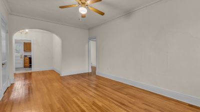 Living area at The Tuscany at Midtown Place, with hardwood floors and an arched opening to the adjoining room.