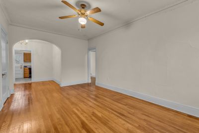 Living area at The Tuscany at Midtown Place, with hardwood floors and an arched opening to the adjoining room.