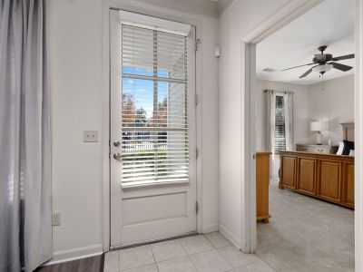 Interior apartment entryway showing a white door with blinds that looks toward a modern bedroom suite at The Westbury apartments near Germantow