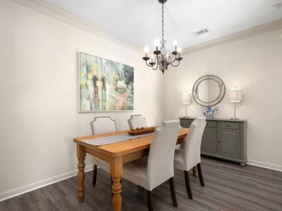 Elegant dining room layout featuring a wooden table with upholstered chairs beneath a classic dark iron chandelier at The Westbury apartments near Germantown.