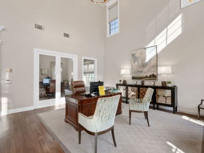 Professional leasing office interior showcasing a classic wooden executive desk and patterned armchairs at The Westbury apartments near Germantown.