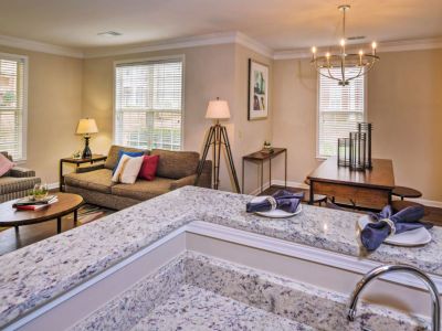View from behind a granite kitchen breakfast bar looking out into the fully furnished living room and adjacent dining space at The Westbury apartments near Germantown.