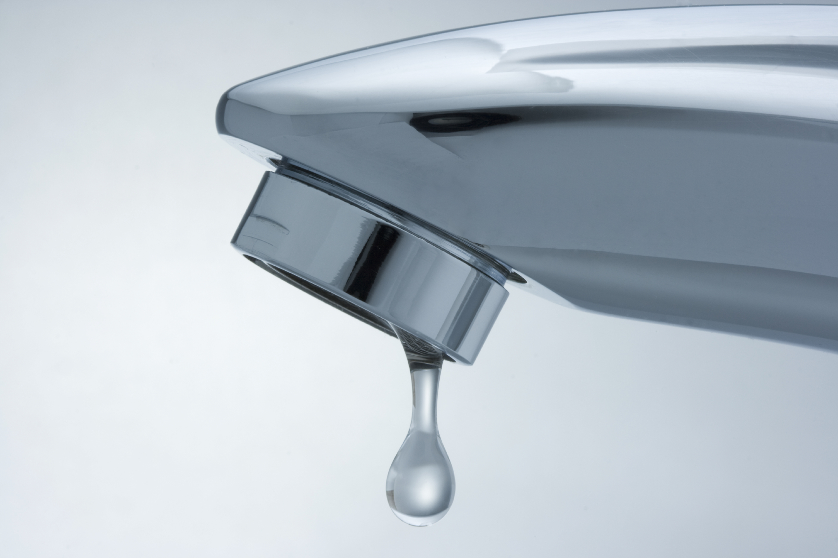 Faucet with a droplet of water. Close-up