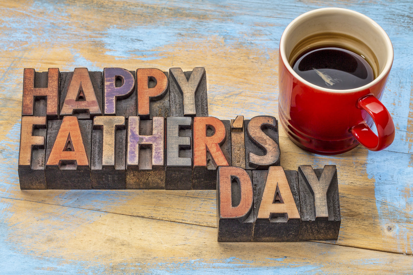 happy father's day in vintage wood letterpress printing blocks with a cup of coffee